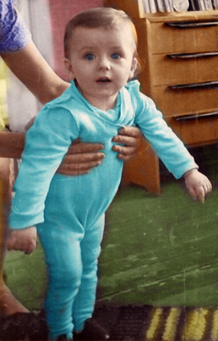 Meelis Luks beebina, jalad maha toetatud, teda püsti hoidva ema toel.